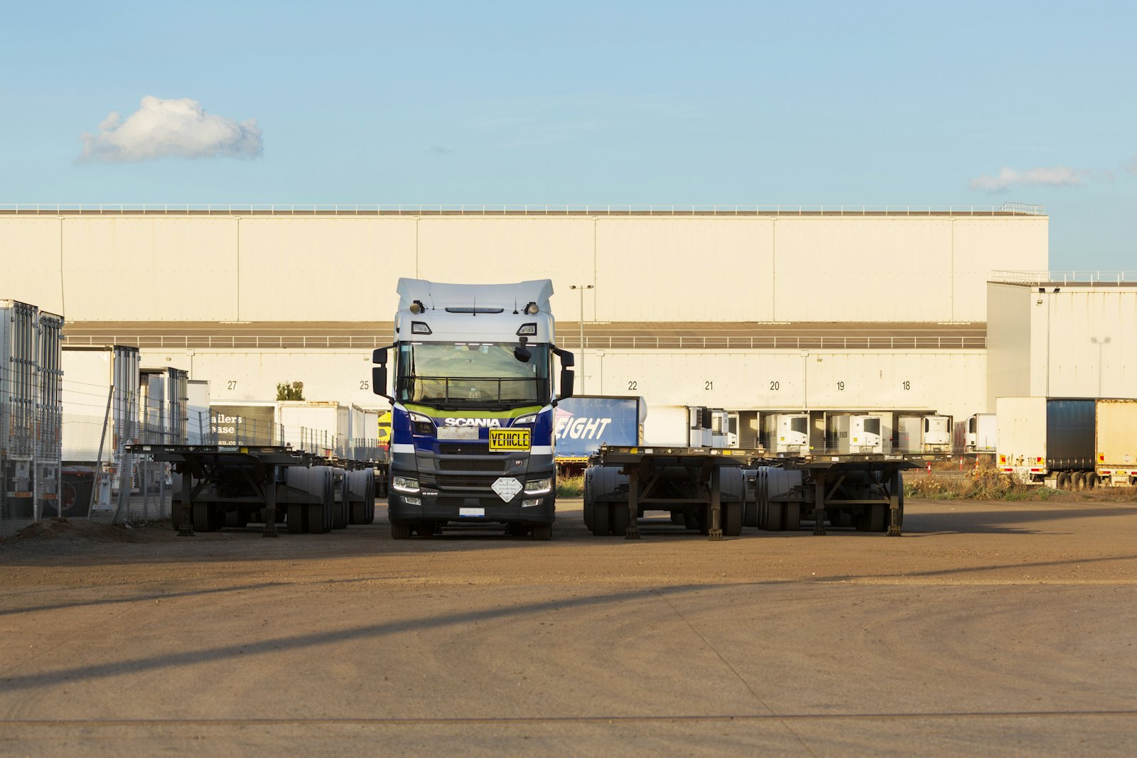 Truck tractor and trailers staged at a warehouse loading area